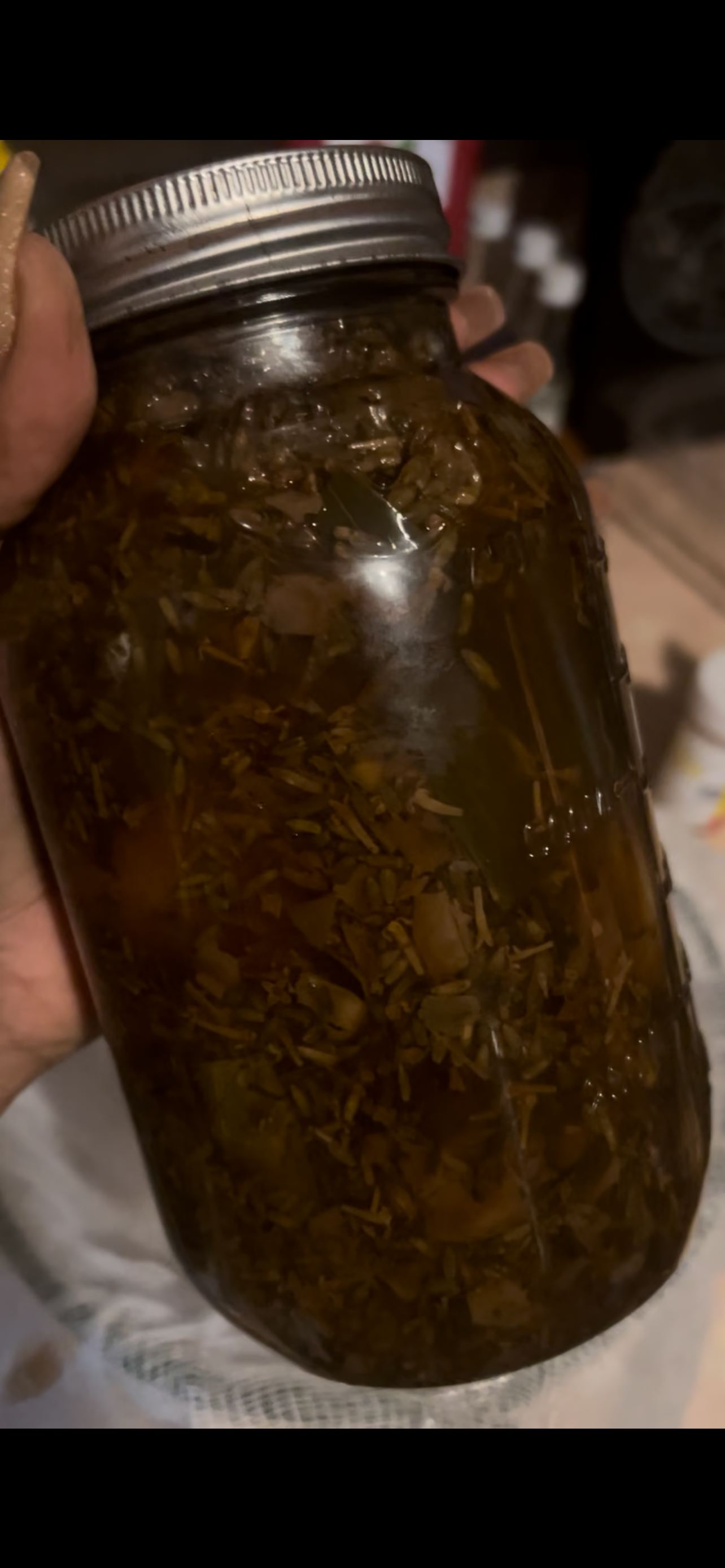 Handcrafted lilac botanical infusion aging in a glass jar as part of the two-year Soft Girl spiritual bath process.